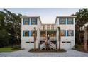 Charming two-story home with blue shutters, dual garages, and well-manicured landscaping at 14 55Th Ave, Isle of Palms, SC 29451