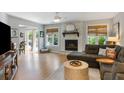 Comfortable living room with a stone fireplace, plenty of natural light, hardwood floors and a modern ceiling fan at 1406 Oaklanding Rd, Mount Pleasant, SC 29464