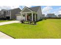 Lovely exterior view with well-maintained landscaping, a covered porch, and an attached two-car garage at 160 Greenbelt Ct, Summerville, SC 29485