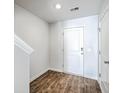 Bright entryway features a wood-look floor, a front door, and white walls at 166 Rosefield Ct, Summerville, SC 29485