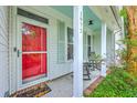 Inviting front porch with rocking chairs and a bright red screen door, adorned with classic shutters at 1972 Gray Battery Ct, Mount Pleasant, SC 29464