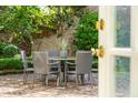 Outdoor patio featuring a dining table, chairs, brick paving, and lush greenery at 2 Bedons Aly, Charleston, SC 29401