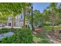 Serene street view showcasing a row of townhouses, mature trees, and verdant landscaping at 2036 Kings Gate Ln, Mount Pleasant, SC 29466