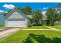 Well-maintained single-story home with lush lawn, attached garage and sidewalk leading to front door at 207 Apache Dr, Summerville, SC 29483
