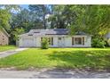 Charming single-story home with solar panels, lush lawn, and mature trees at 207 Terry Ave, Summerville, SC 29485
