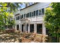 Stately white home with dark green shutters, complemented by an outdoor brick patio and seating area at 22 Lamboll St # C, Charleston, SC 29401