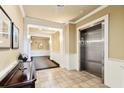 Well-lit hallway with tiled floor, elevator access, and classic architectural details at 2244 Ashley Crossing Dr # 1125, Charleston, SC 29414