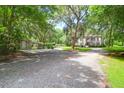 Scenic view of a home with a gravel driveway, a shed, and beautiful mature trees at 2494 Cape Rd, Johns Island, SC 29455