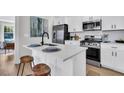 Modern kitchen with white cabinets, stainless steel appliances, a quartz countertop island, and stylish stools at 2949 Alabama Dr, North Charleston, SC 29405