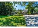 Charming home with a landscaped front yard, mature trees, and a gravel driveway at 3002 Waterway Blvd, Isle of Palms, SC 29451