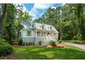 Beautiful two-story home with a inviting porch and a lush green lawn surrounded by trees at 338 Mcclellan Ave, McClellanville, SC 29458