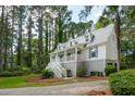 Lovely two-story house featuring a spacious front porch, set amidst a backdrop of towering trees at 338 Mcclellan Ave, McClellanville, SC 29458