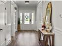 Bright foyer features white trim, a wood-look floor, console table and decorative mirror at 360 Parish Farms Dr, Summerville, SC 29486