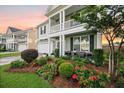 Inviting home exterior featuring a well-maintained lawn, colorful flowerbeds, and a cozy front porch at 529 Dunswell Dr, Summerville, SC 29486