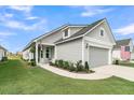 Home featuring light gray siding, a two-car garage, and well-manicured landscaping at 753 Blue Iris Way, Summerville, SC 29486