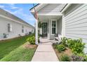 Inviting front porch with a seating area and decorative plants at 753 Blue Iris Way, Summerville, SC 29486