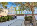 A row of colorful townhomes, each with a garage and well-maintained front landscaping for an inviting curb appeal at 9024 Parlor Dr, Ladson, SC 29456