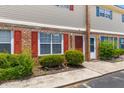 Inviting townhouse features brick facade, red shutters, green landscaping, and an inviting entryway at 107 Hickory Ln # C, Ladson, SC 29456