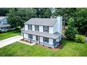 Aerial view of a charming home with a well-maintained lawn and mature trees surrounding the property at 107 Sugarpine Pl, Summerville, SC 29486