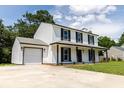 Charming two-story home featuring a covered porch and attached garage on a sunny day at 107 Sugarpine Pl, Summerville, SC 29486