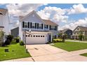 Charming two-story home with light blue siding, black shutters, and a two-car garage with a basketball hoop at 109 Goose Rd, Summerville, SC 29483