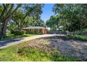 Home exterior with driveway, chimney, landscaping, and outdoor swing set at 1126 Brigantine Dr, Charleston, SC 29412