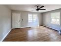 Bright living room with hardwood floors, fresh paint, new ceiling fan, and large windows at 114 Madison St, Walterboro, SC 29488
