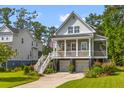 Beautiful home with a front porch, a two-car garage, lush landscaping and plenty of curb appeal at 129 Martins Point Dr, Wando, SC 29492