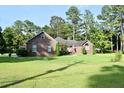 Inviting brick home featuring lush landscaping and a well-maintained lawn, creating a picturesque and serene setting at 1457 Green Pond Hwy, Walterboro, SC 29488