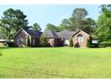 Beautiful brick home with a neatly trimmed lawn, showcasing its traditional architecture and serene surroundings at 1457 Green Pond Hwy, Walterboro, SC 29488
