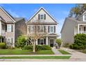 Charming two-story home featuring gray siding, black shutters, and a well-maintained front yard at 1821 Towne St, Johns Island, SC 29455