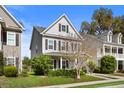 Charming two-story home featuring gray siding, black shutters, and a well-maintained front yard at 1821 Towne St, Johns Island, SC 29455