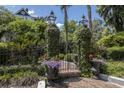 Elegant gated entrance with lanterns, brick path, and lush foliage, exuding curb appeal and privacy at 208 Sumter Ave, Summerville, SC 29483