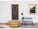 Inviting front entrance with a wooden door, a small porch with seating, and decorative accents at 2157 Jeff St, North Charleston, SC 29405