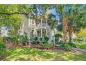 Lovely two-story home boasts a welcoming front porch, balcony, and meticulously maintained landscaping at 2228 Daniel Island Dr, Charleston, SC 29492