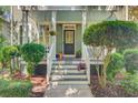 Inviting front porch features a cozy seating area and decorative plants, showcasing the home's curb appeal at 2228 Daniel Island Dr, Charleston, SC 29492