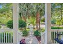 Scenic view from the front porch overlooks a beautifully landscaped yard and quiet neighborhood street at 2228 Daniel Island Dr, Charleston, SC 29492