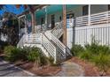 Welcoming front stairway leading to a bright porch and entry featuring beautiful tropical landscaping at 2514 Myrtle Ave, Sullivans Island, SC 29482