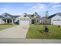 Inviting home with a wide driveway, tidy lawn, covered porch, and attractive exterior details at 274 Tupelo Lake Dr, Summerville, SC 29486