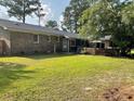 Spacious backyard featuring a patio, brick accents, and a well-maintained lawn at 306 Park St, Saint George, SC 29477