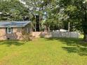 View of a grassy backyard featuring a wood fence and mature trees at 306 Park St, Saint George, SC 29477