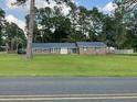 Inviting brick home with a lush front yard and mature trees, enhancing curb appeal at 306 Park St, Saint George, SC 29477
