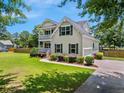 View of the home's exterior with a well-maintained lawn and a paved driveway at 309 Pinopolis Park Dr, Moncks Corner, SC 29461