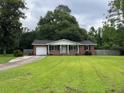A well-maintained lawn, a driveway and landscaping complement this red brick home's classic curb appeal at 352 Oxford Rd, Ladson, SC 29456