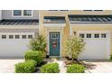 Inviting yellow townhome entrance with a blue door, complemented by decorative shrubbery and a seasonal wreath at 412 Grand Palm Ln, Summerville, SC 29485