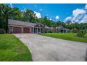 Home with long driveway leading to a charming single-story home with an attached garage at 439 Temple Rd, Ladson, SC 29456