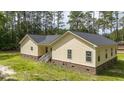 Exterior view of a yellow home, highlighted by the new roof and vinyl siding at 480 Longleaf Dr, Walterboro, SC 29488