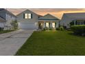 Charming yellow two-story home with a well-manicured lawn, attached garage, and welcoming front porch at 504 Dolphin Dr, Summerville, SC 29485
