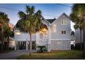Charming beach home with elevated construction, a lush lawn and well-maintained yard at 505 E Arctic Ave, Folly Beach, SC 29439