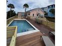Private pool with deck area, lounge chairs, palm trees, and home in the background at 509 W Ashley Ave, Folly Beach, SC 29439
